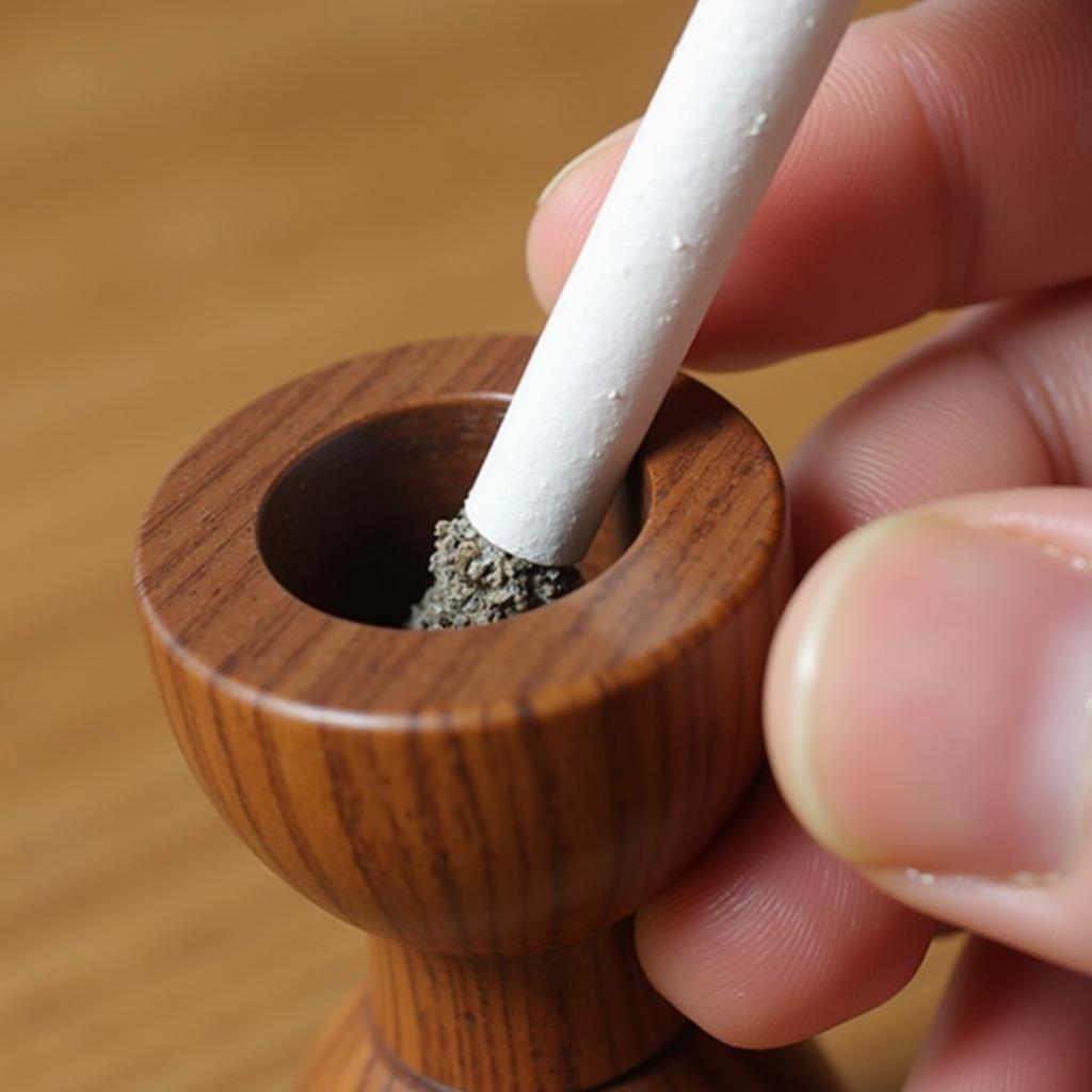 Cleaning a wooden cigarette holder with a pipe cleaner