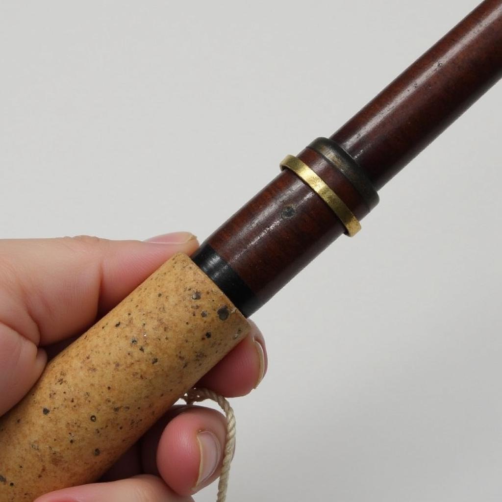 Close-up of the cork grip and reel seat on a used Winston fly rod, showing signs of wear and tear that add to its character