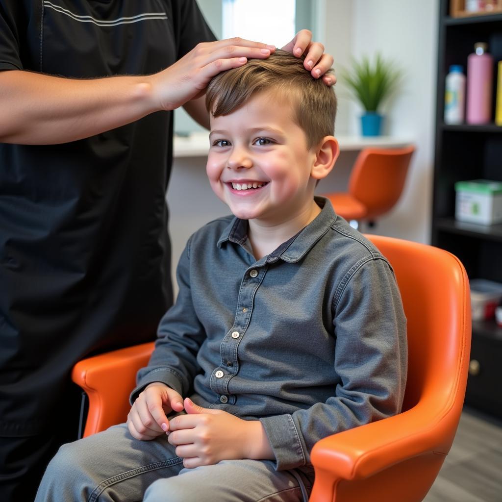 A young boy smiling while getting a haircut in a comfortable salon booster seat