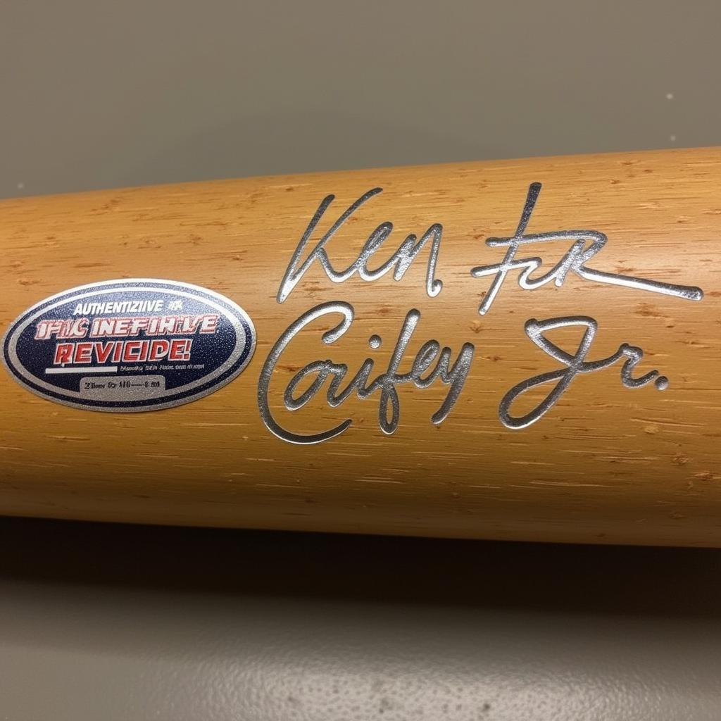 Close-up image of Ken Griffey Jr's signature and authentication hologram on a baseball bat