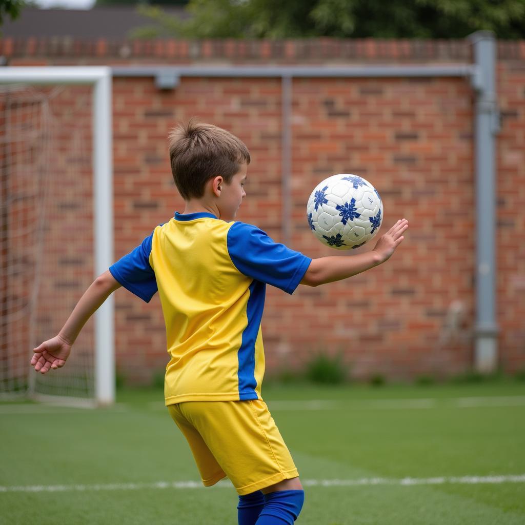 Young footballer practicing wall passes