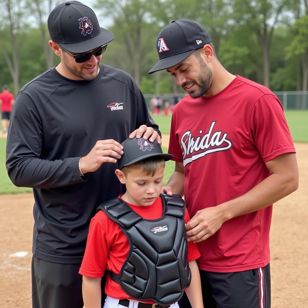 A parent helping a young catcher try on a chest protector 