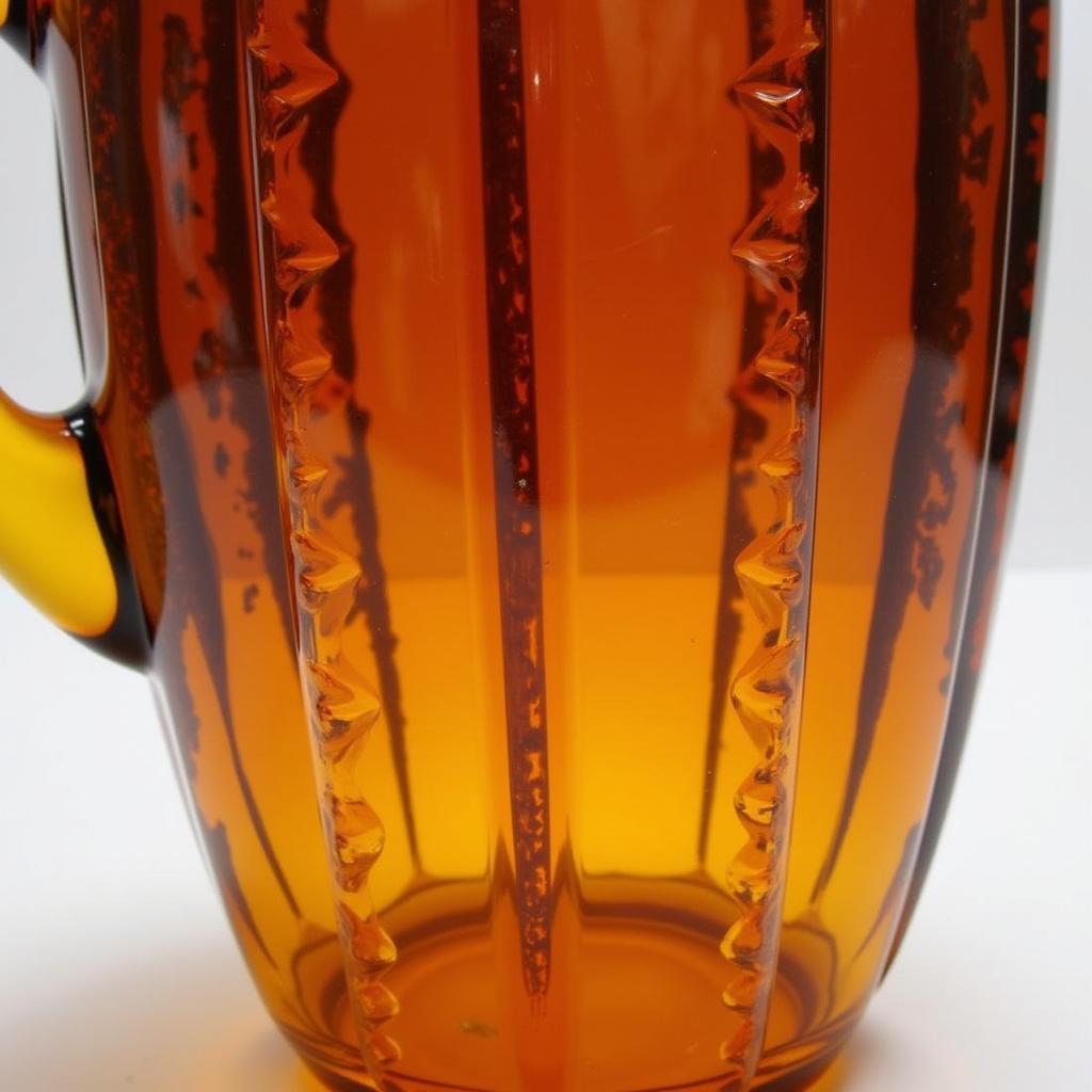 Close-up view of an amber pitcher showing its intricate design and color variations